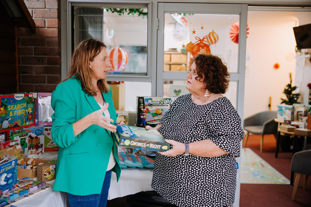 Kylie Toynton speech pathologist at Small Moments Speech & Play working with an adult and discussing how to use a game for therapy NDIS personalsised therapy programs.