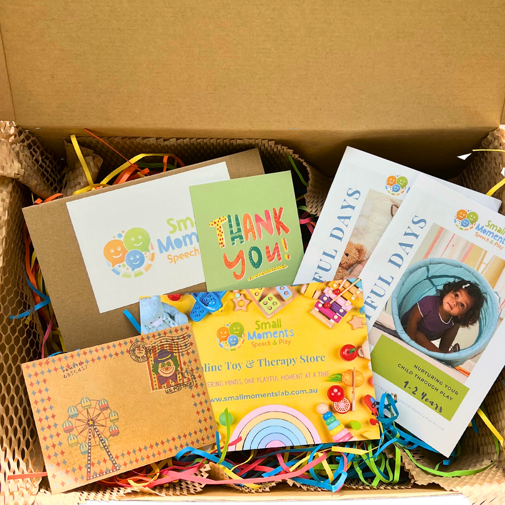 Image shows the inside of the product box include thank you card, play guides and therapy guides for the playtime at home therapy kit